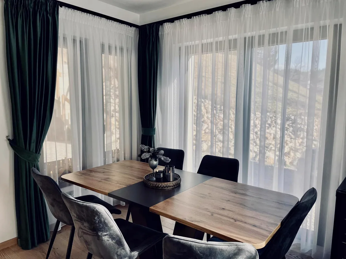 Dining room with green curtains and view of nature