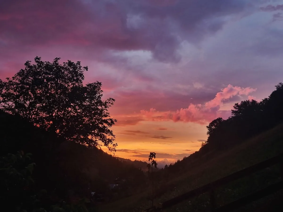Dramatic sunset with purple and orange sky over the Holbav valleys