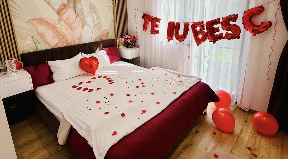 Dormitor decorat romantic cu petale și lumânări