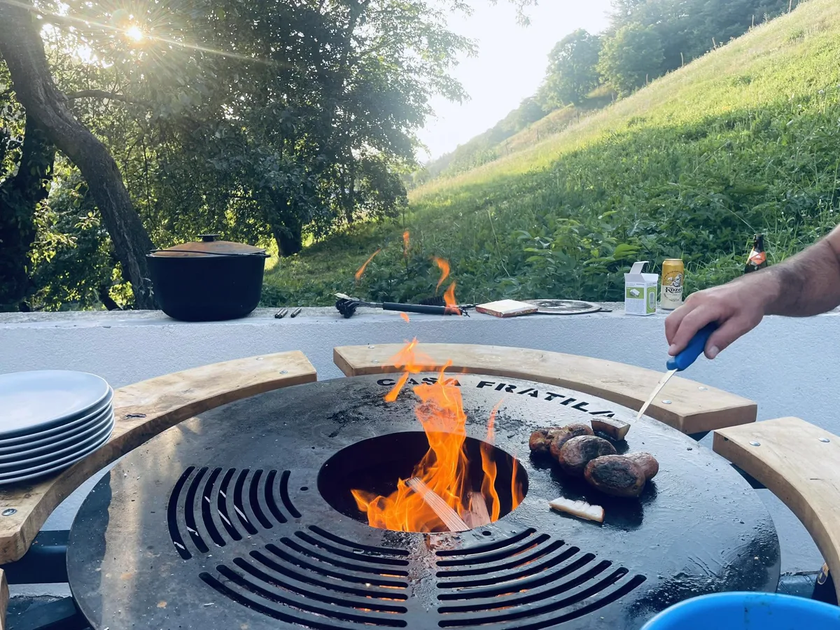 Casa Frătilă BBQ — meat on the fire in midday light
