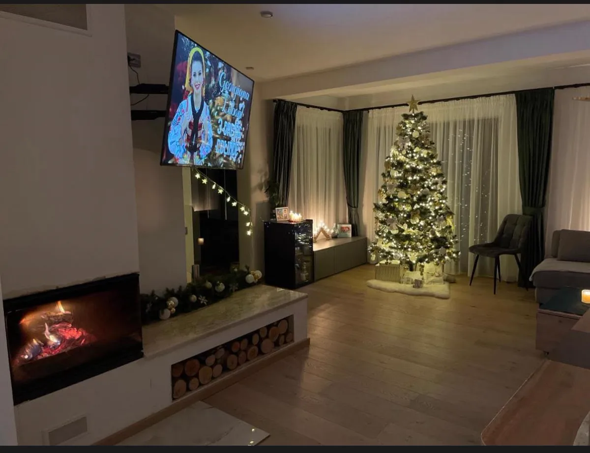 Christmas living room with golden tree and lit fireplace