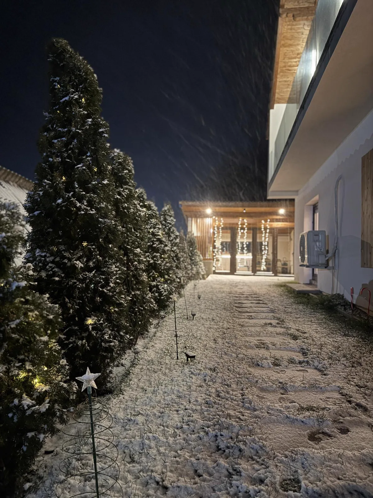 Casa Frătilă at night with snow and fairy lights