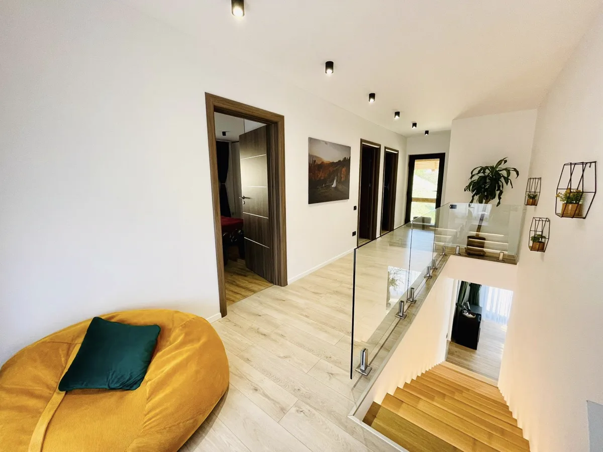 Upper hallway with glass balustrade and yellow armchair